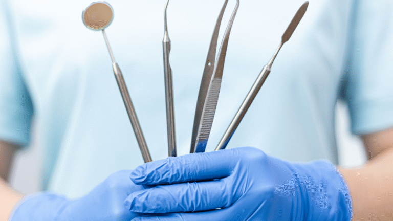 Gloved dentist holding a set of stainless steel dental diagnostic tools